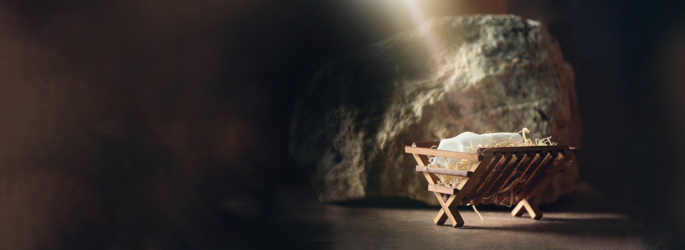 Christian Christmas Concept. Birth of Jesus Christ. Wooden Manger in Cave Background. Banner, Copy Space. Nativity Scene Symbol. Jesus Is Reason for Season. Salvation, Messiah, Emmanuel, God with Us, Hope